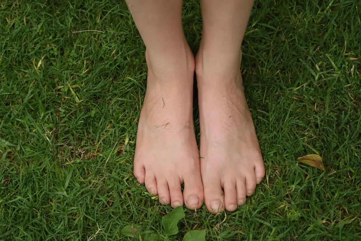 Pieds nus posés côte à côte dans l’herbe